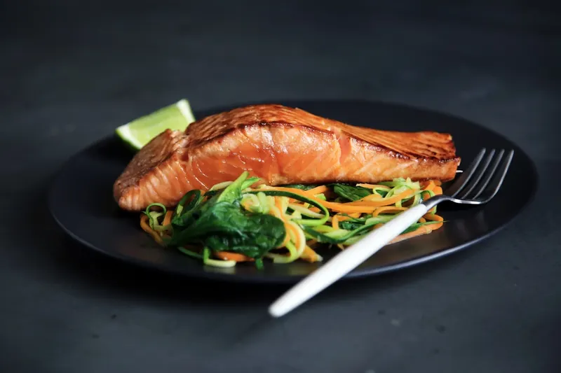 Filet de truite rosé servi sur un lit de légumes croquants
