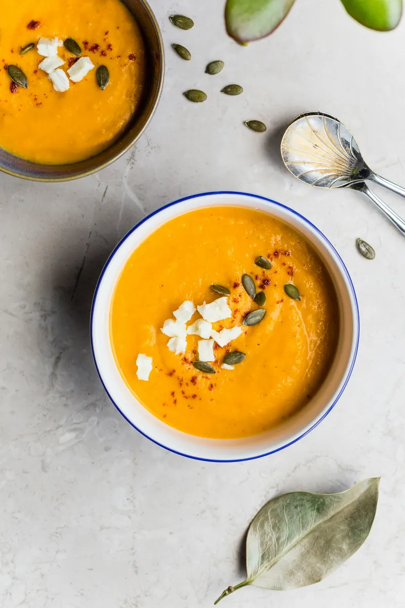 Bol de velouté de courge garni de graines et de fromage frais