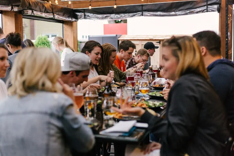 Longue table occupée par un groupe partageant un repas